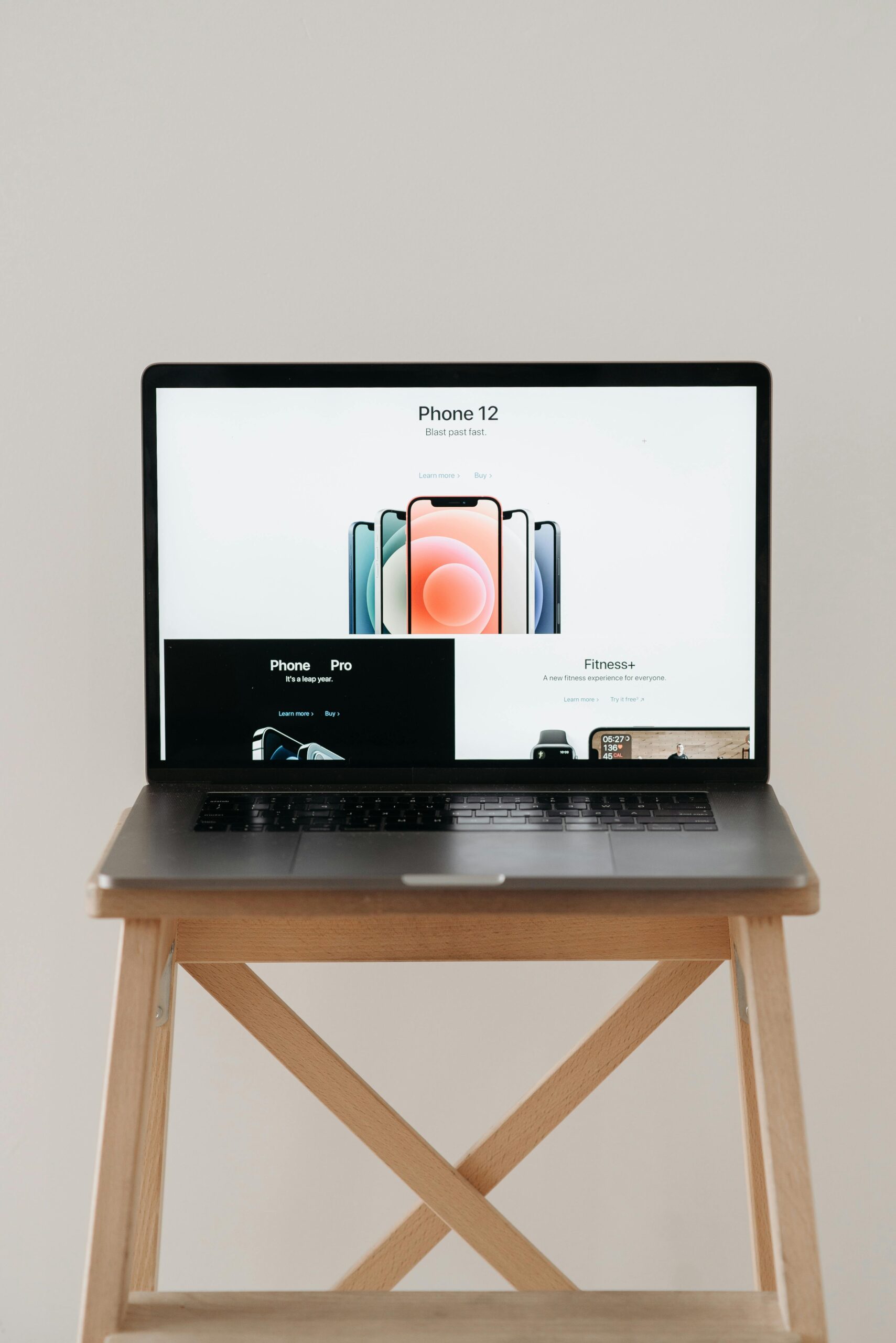 A sleek laptop on a wooden table showing a smartphone advertisement, perfect for tech and gadget content.